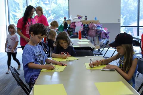 Summer-Discovery-participants-color-while-camp-counselors-supervise.jpg