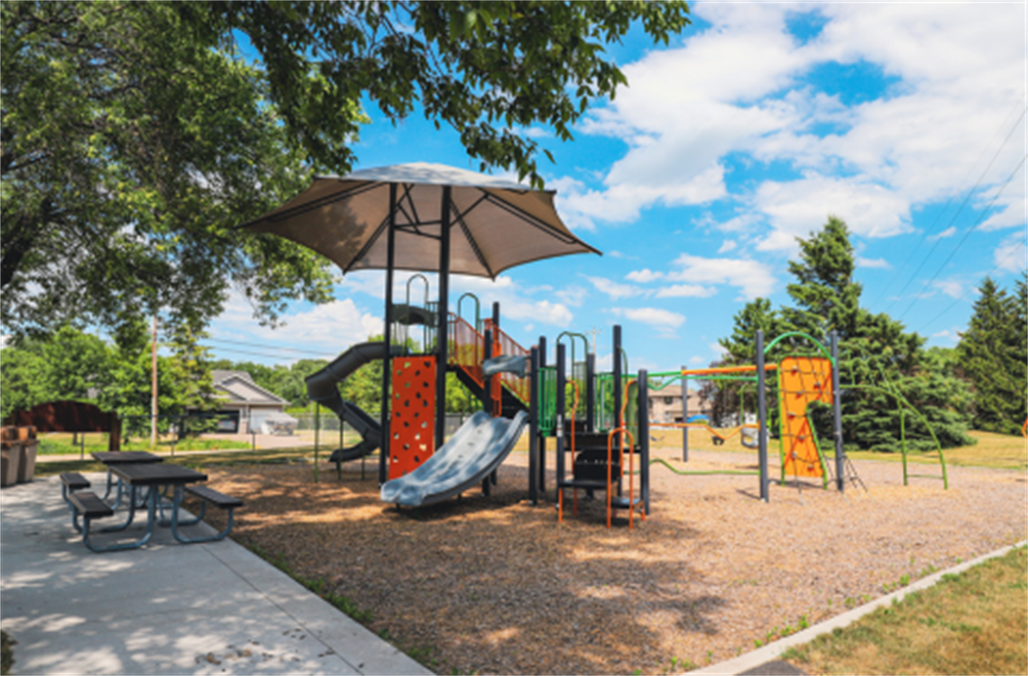 Small neighborhood playground structure featuring slides, swings and climbing structures