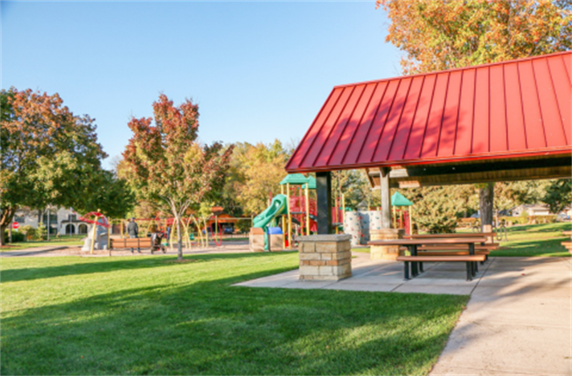 Picnic shelter in foreground with a playground in the background